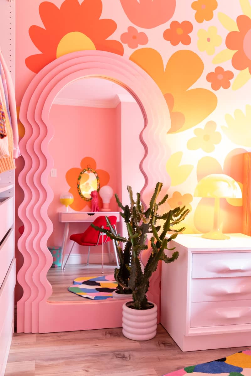 Pink wavy full length mirror in colorful bedroom.