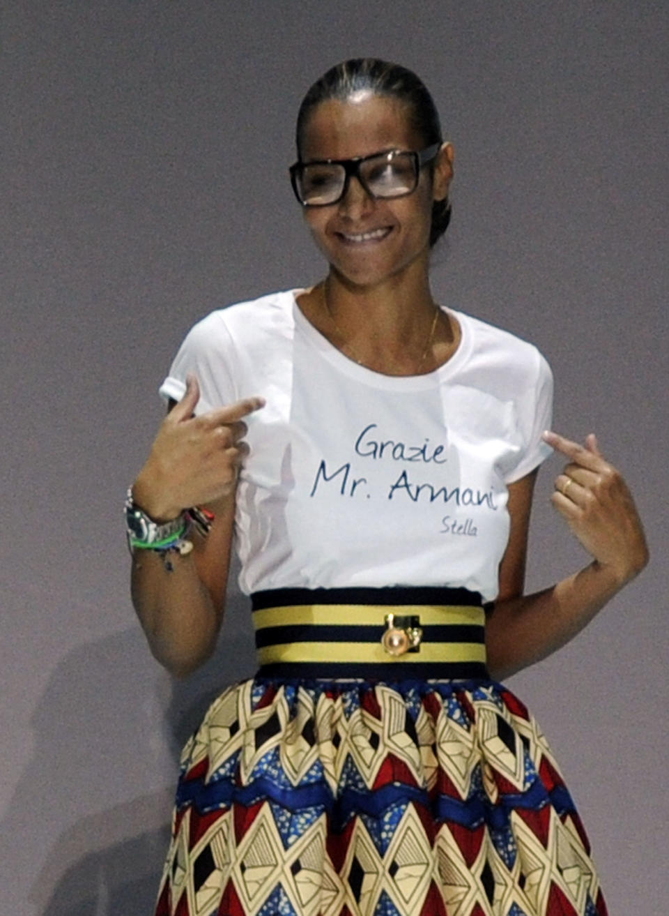 Designer Stella Jean acknowledges the audience as she wears a shirt with writing in Italian reading "Thank you Mr. Armani", at the end of her women's Spring-Summer 2014 collection, part of the Milan Fashion Week, unveiled in Milan, Italy, Saturday, Sept. 21, 2013. Renowned Italian designer Giorgio Armani hosted the fashion show of emerging designer Stella Jean at the Armani Theater, his show space. (AP Photo/Giuseppe Aresu)