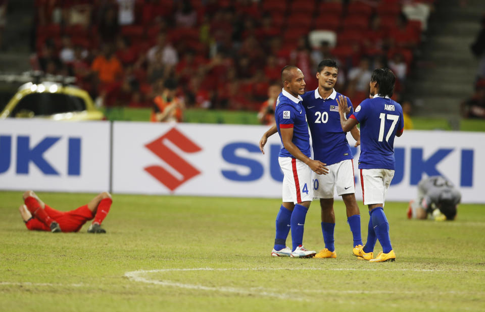 Malaysian players celebrate defeating Singapore in their AFF Suzuki Cup Group B match at the National Stadium in Singapore on 29 November 2014.