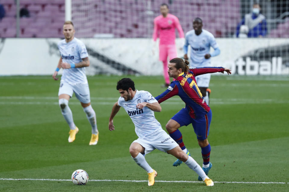 Gonçalo Guedes, del Valencia, izquierda, disputa un balón con Antoine Griezmann de Barcelona en partido por La Liga española en el Nou Camp, Barcelona, España, sábado 19 de diciembre de 2020. (AP Foto/Joan Monfort)