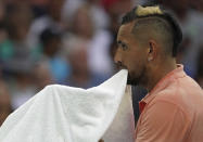 Australia's Nick Kyrgios carries his towel in his mouth during his second round singles match against France's Gilles Simon at the Australian Open tennis championship in Melbourne, Australia, Thursday, Jan. 23, 2020. (AP Photo/Lee Jin-man)