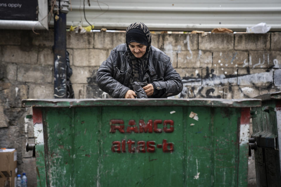 Hoda, a 57-year-old Lebanese scavenger, searches in a garbage container, in Beirut, Lebanon, Saturday, Jan. 13, 2022. As Lebanon faces one of the world’s worst financial crises in modern history, now even its trash has become a commodity fought over in the street. (AP Photo/Lujain Jo)