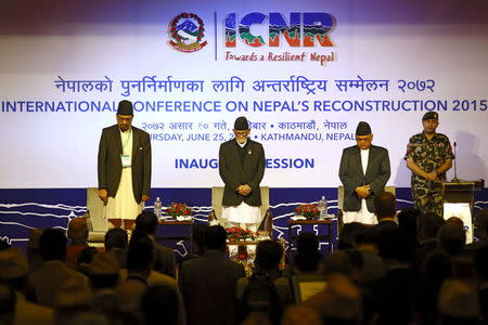 Nepal's Prime Minister Sushil Koirala (C) along with Minister for Finance Ram Sharan Mahat (L) and Minister for Foreign Affairs Mahendra Bahadur Panday (2nd R) observe one minute of silence in memory of earthquake deceases during the International Conference of Nepal Reconstruction in Kathmandu, June 25, 2015. REUTERS/Navesh Chitrakar