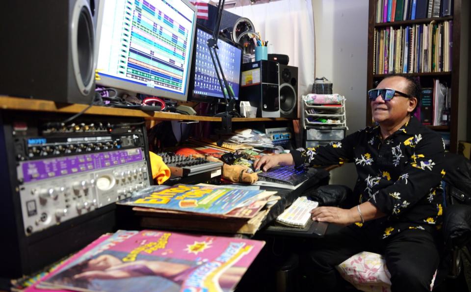 A man in black sunglasses operates a music studio