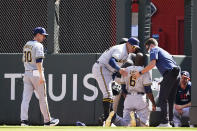 Milwaukee Brewers center fielder Lorenzo Cain (6) is attended to after an injury while trying to make a catch against Atlanta Braves' Adam Duvall during the fourth inning of Game 3 of a baseball National League Division Series, Monday, Oct. 11, 2021, in Atlanta. (AP Photo/John Bazemore)