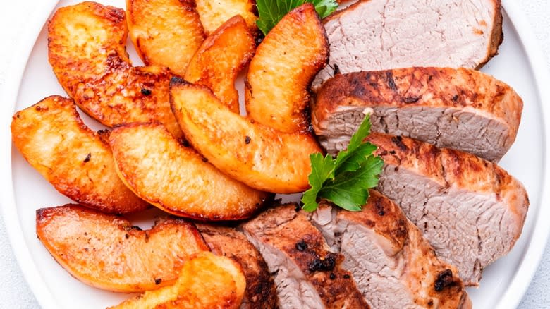 Top-down close-up of pork tenderloin slices with cooked apples