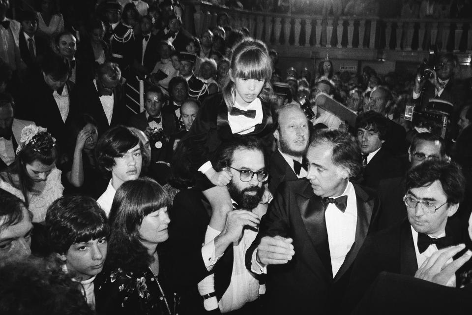 ARCHIVO - El director estadounidense Francis Ford Coppola, en el centro, lleva a su hija Sofía, de 8 años, entre la multitud después de la presentación formal de la película estadounidense "Apocalypse Now", en el Festival de Cine de Cannes en Francia, el 19 de mayo de 1979. Su hijo Gian Carlo, 15 años y su esposa Ellie están de pie. Coppola regresa a Cannes con su más reciente película "Megalopolis". (Foto AP/Jean-Jacques Levy, archivo)