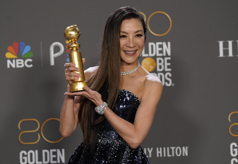 Michelle Yeoh poses in the press room with the award for best performance by an actress in a motion picture, musical or comedy for 