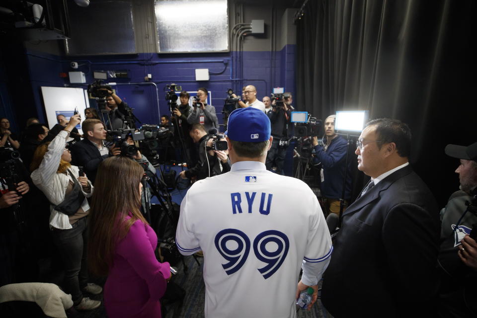 Toronto Blue Jays newly signed pitcher Hyun-Jin Ryu, center, speaks to media during a news conference announcing his signing to the team in Toronto, Friday, Dec. 27, 2019. (Cole Burston/The Canadian Press via AP)