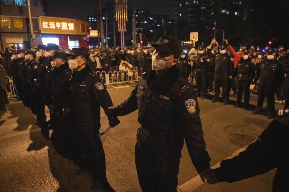 Chinese policemen form a line to stop protesters marching