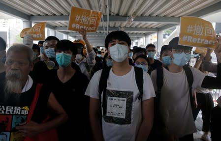 Protesters hold placards and shout slogans on a footbridge leading to the Legislative Council in Hong Kong