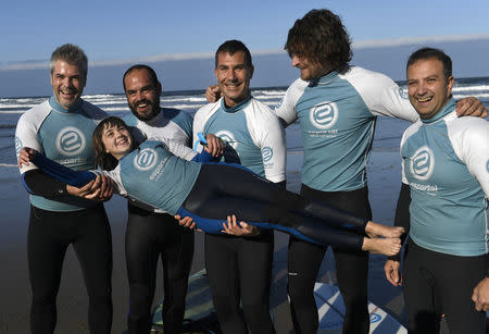 Carmen Lopez Garcia, Spain's first blind female surfer who is to participate in the ISA World Adaptive Surfing Championship, and her coach Lucas Garcia pose for a photo with friends after training at Salinas beach, Spain, December 6, 2018. REUTERS/Eloy Alonso