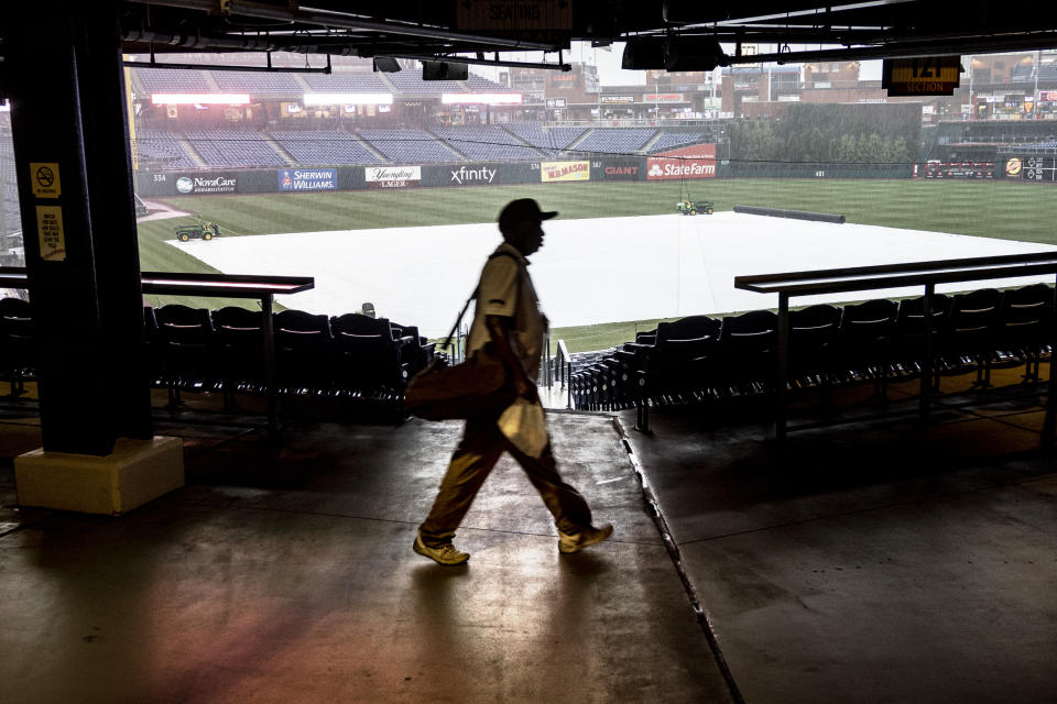Workers leave the stadium after the the Miami Marlins versus he Philadelphia Phillies baseball game was called due to rain on Thursday, July 1, 2021, in Philadelphia. (AP Photo/Laurence Kesterson)