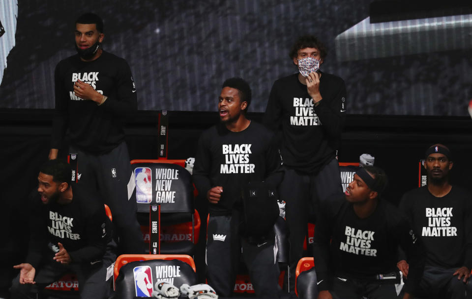 Sacramento Kings players cheer from the bench while wearing Black Lives Matters shirts in the first half of an NBA basketball game against the San Antonio Spurs, Friday, July 31, 2020, in Lake Buena Vista, Fla. (Kim Klement/Pool Photo via AP)