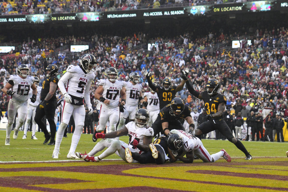 Players reacting to interception by Washington Commanders cornerback Kendall Fuller (29) against Atlanta Falcons running back Cordarrelle Patterson (84) during the second half of an NFL football game, Sunday, Nov. 27, 2022, in Landover, Md. Washington won the game 13-19. (AP Photo/Jessica Rapfogel)