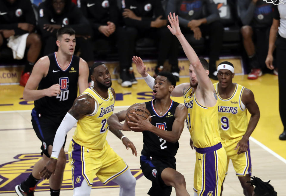 Los Angeles Clippers’ Shai Gilgeous-Alexander, center, looks to pass under the basket between Los Angeles Lakers’ LeBron James, second from left, and Mike Muscala, second from right, during the first half of an NBA basketball game Monday, March 4, 2019, in Los Angeles. (AP Photo/Marcio Jose Sanchez)t,