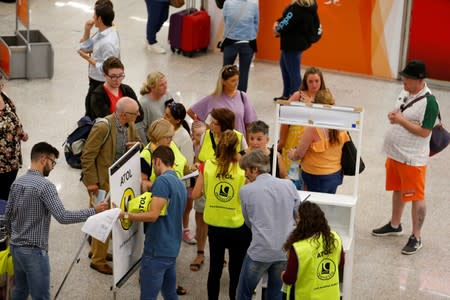 Passengers talk to Civil Aviation Authority employees at Mallorca Airport as an announcement is expected on the Thomas Cook's tour operator, in Palma de Mallorca