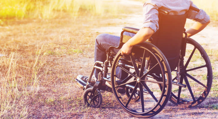 Image of person in a field sitting in a wheelchair