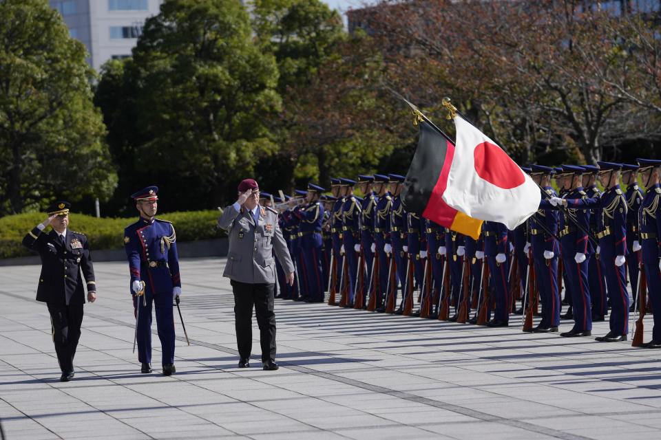 Gen. Eberhard Zorn, chief of defense of the German Armed Forces, center, and Gen. Koji Yamazaki, left, chief of Staff, Joint Staff of the Japan Self-Defense Forces, salute as they observe an honor guard at the Ministry of Defense in Tokyo, Friday, Nov. 5, 2021. (AP Photo/Hiro Komae)