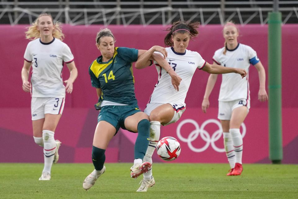 Australia player Alanna Kennedy (14) tries to clear the ball from U.S. player Alex Morgan (13) during the Tokyo Olympics.