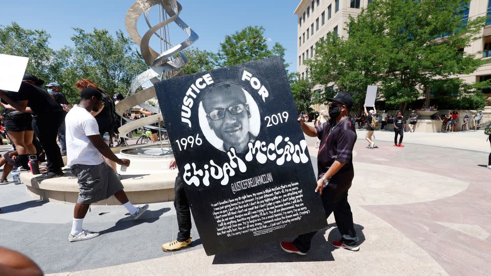 Demonstrators carried a giant placard during protests on June 27, 2020, outside the police department in Aurora. - David Zalubowski/AP/File