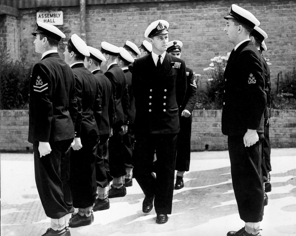 FILE - In this July 31, 1947 file photo, Lieut. Philip Mountbatten, center, inspects his men at the Petty Officers' Training Center at Corsham, England. Buckingham Palace officials say Prince Philip, the husband of Queen Elizabeth II, has died, it was announced on Friday, April 9, 2021. He was 99. Philip spent a month in hospital earlier this year before being released on March 16 to return to Windsor Castle. Philip, also known as the Duke of Edinburgh, married Elizabeth in 1947 and was the longest-serving consort in British history. (AP Photo/File)