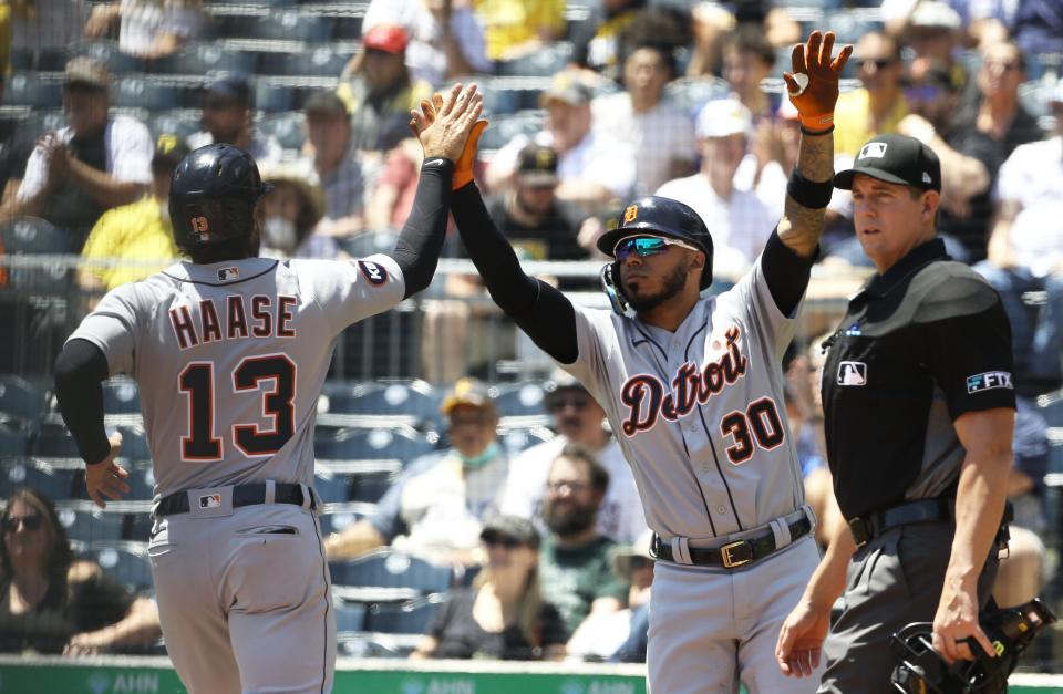 Tigers  third baseman Harold Castro (30) high-fives catcher Eric Haase as he crosses home plate and scores a run against the Pirates during the second inning June 8, 2022 at PNC Park in Pittsburgh.