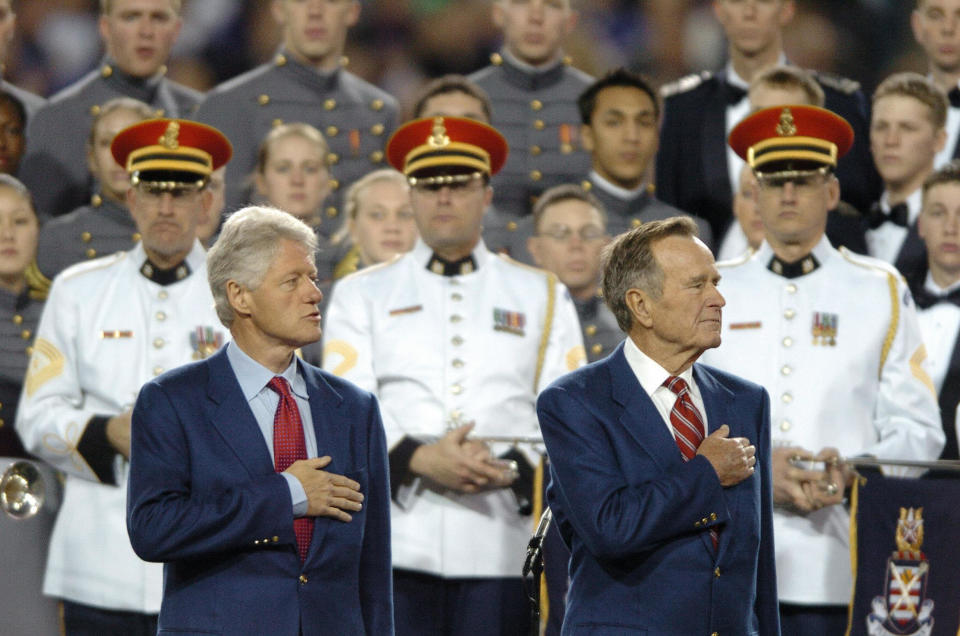 Former US presidents George H.W. Bush (R) and Bill Clinton listen to the national anthem sung by the combined choirs of the U.S. Military Academy&nbsp;the U.S. Naval Academy, the U.S. Air Force Academy, and the U.S. Coast Guard Academy, and the U.S. Army Herald Trumpets&nbsp;before the start of Super Bowl XXXIX between the Philadelphia Eagles and the New England Patriots on Feb. 6, 2005&nbsp;at Alltel Stadium in Jacksonville, Florida.&nbsp;