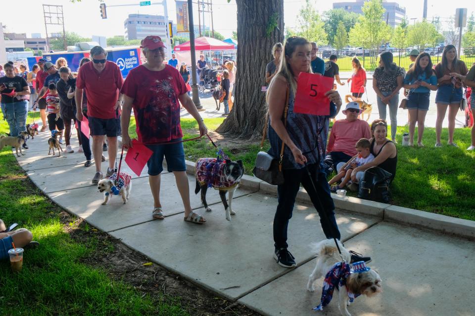 Pets and owners line up to walk past judges for the patriotic pet parade in honor of the Fourth of July Saturday morning at the Amarillo Community Market.