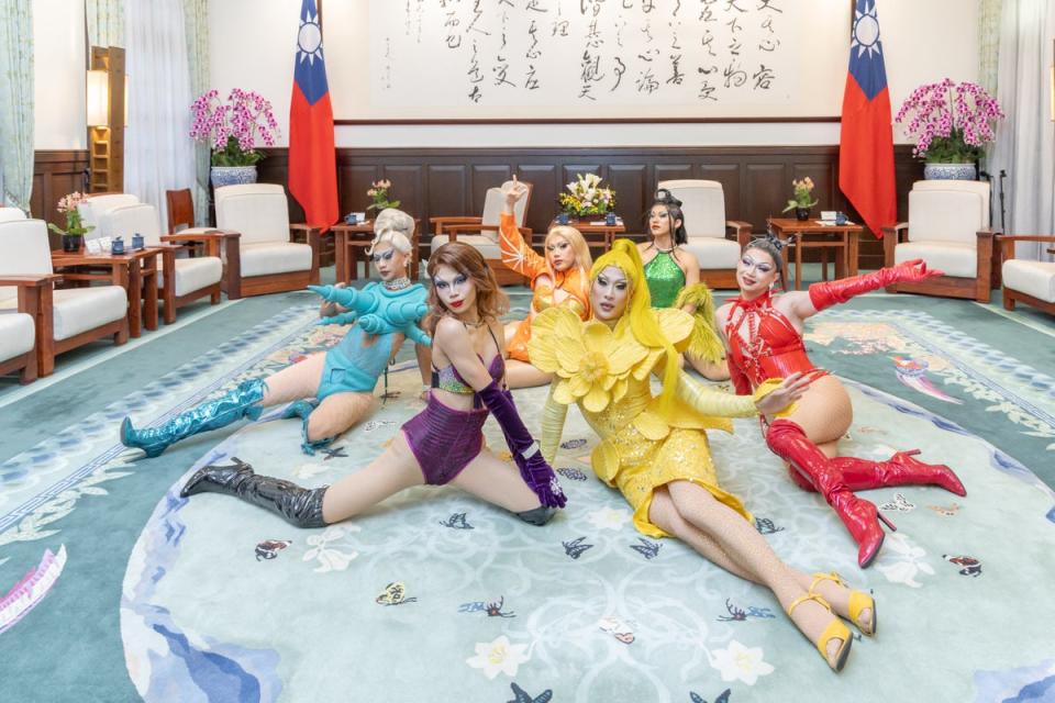 Nymphia Wind, dressed in yellow, and her team pose for photos at the presidential office in Taipei (AFP)