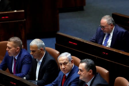 FILE PHOTO: Israeli Prime Minister Benjamin Netanyahu sits with his ministers and former Israel's Defence Minister Avigdor Lieberman at the plenum at the Knesset, Israel's parliament, in Jerusalem