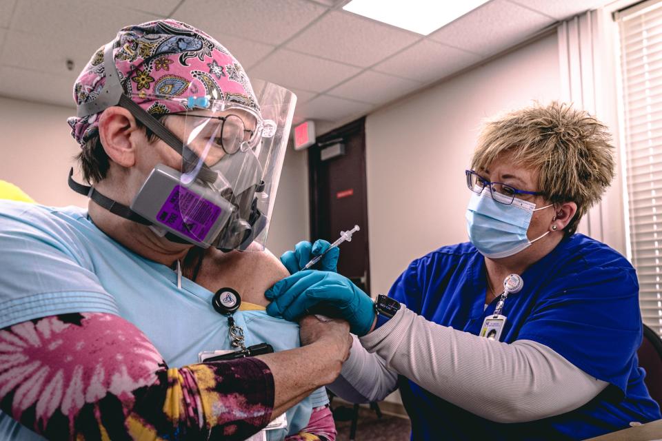 Jennifer Raymond, a registered nurse who works in the COVID-19 unit at Ascension St. John Jane Phillips, was the first nurse from the hospital to get Pfizer's new coronavirus vaccine last December. Washington County Health Department's Tiffaney Stump administered the shot.