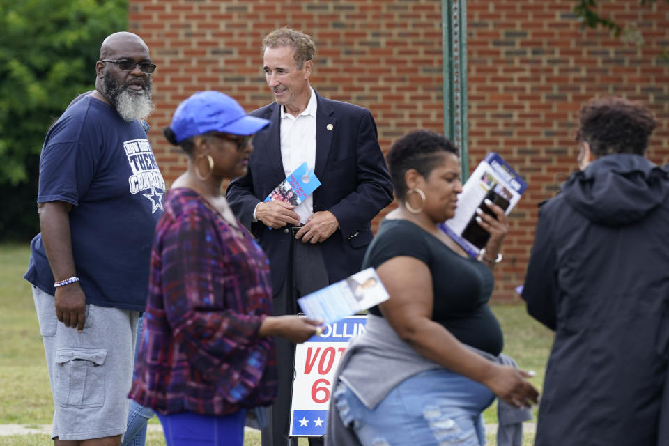 Virginia State Sen. Joe Morrissey, top center, talks with Leon Warlington Jr., left, as he visits a polling precinct Tuesday, June 20, 2023, in Henrico, Va. Morrissey is facing former Delegate Lashrecse Aird in a Democratic primary for a newly redrawn Senate district. (AP Photo/Steve Helber)