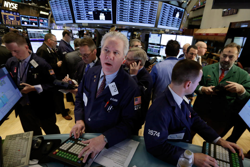 Specialist Brian Egan, foreground left, works on the floor of the New York Stock Exchange, Wednesday, March 5, 2014. Stocks are little changed in early trading, a day after setting a record high, as traders were unimpressed by a slight increase in hiring at private companies last month.(AP Photo/Richard Drew)