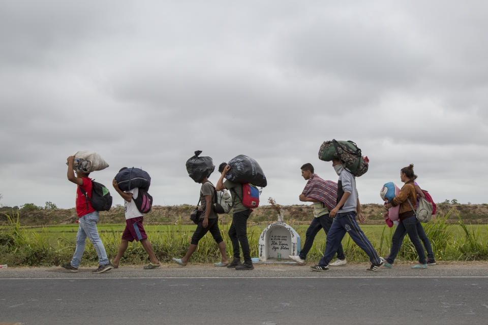 <p>A group of Venezuelans walk along the Panamericana route towards Lima on Aug. 14, 2018 in Tumbes, Peru. (Photo: Manuel Medir/Getty Images) </p>