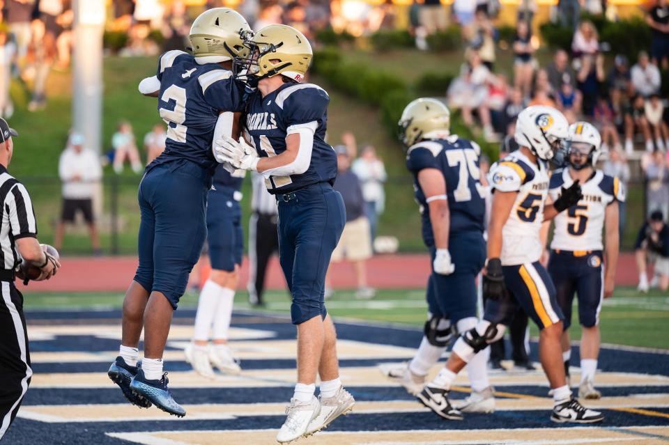 Shrewsbury's Josiah Spiegel, left, and Stephen Surabian celebrate after Spiegel scored the first touchdown of the game versus Acton-Boxborough on Thursday September 14, 2023 in Shrewsbury.