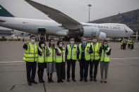 Hong Kong Secretary for Food and Health Sophia Chan, fourth left, and Secretary for the Civil Service Patrick Nip, fourth right, with Cathay Pacific and Fosun Pharma Co. representatives gesture after the delivery of Pfizer-BioNTech coronavirus vaccines at the Hong Kong International Airport in Hong Kong, Saturday, Feb. 27, 2021. (Jerome Favre/Pool Photo via AP)