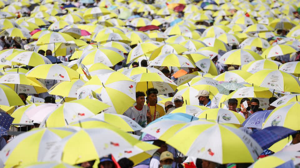 Crowds waiting for Pope Francis sheltering from the sun. - Guglielmo Mangiapane/Reuters