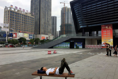 A man rests on a square near a railway station in Bengbu, Anhui province, China July 8, 2017. REUTERS/Yawen Chen