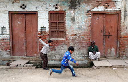 Children play as a man sits outside a house in Nayabans village in Bulandshahr district, Uttar Pradesh, India December 5, 2018. Picture taken December 5, 2018. REUTERS/Adnan Abidi