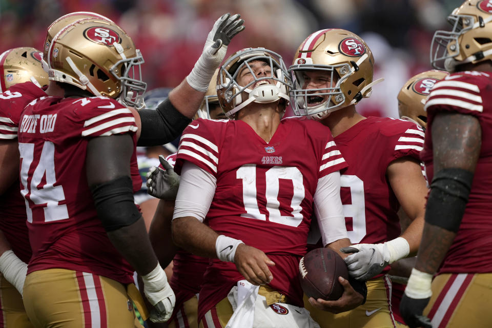 Jimmy Garoppolo (10), quarterback de los 49ers de San Francisco, festeja con sus compañeros durante el partido del domingo 18 de septiembre de 2022, ante los Seahawks de Seattle (AP Foto/Tony Avelar)