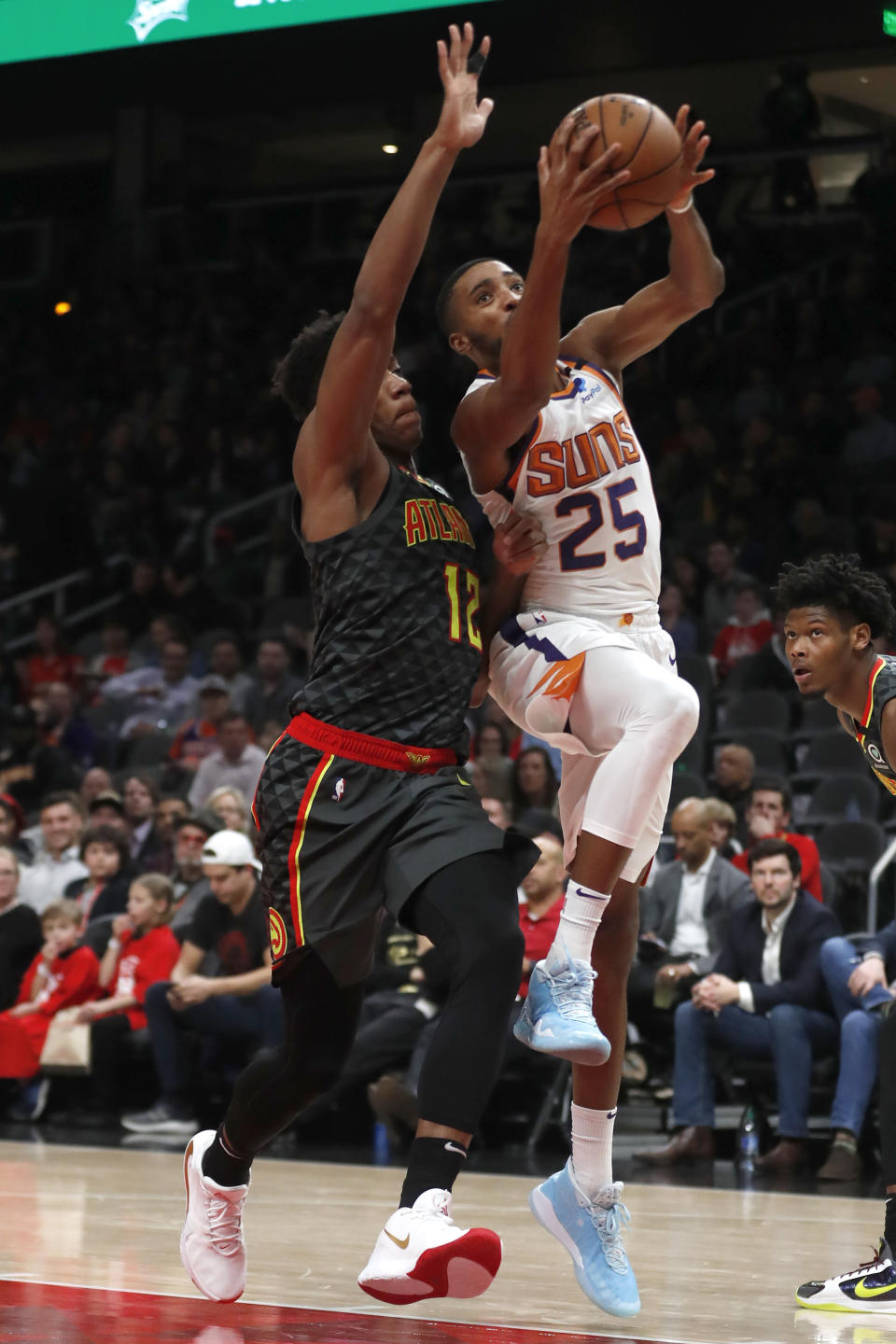 Phoenix Suns forward Mikal Bridges (25) goes to the basket as Atlanta Hawks forward De'Andre Hunter (12) defends in the first half of an NBA basketball game Tuesday, Jan. 14, 2020, in Atlanta. (AP Photo/John Bazemore)