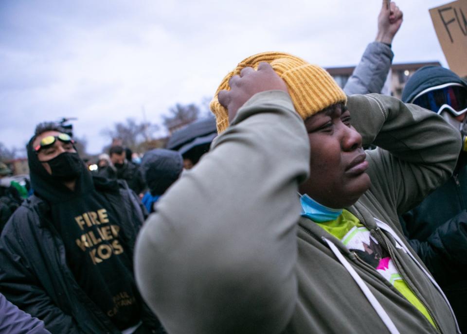 Demonstrator puts hands on head.