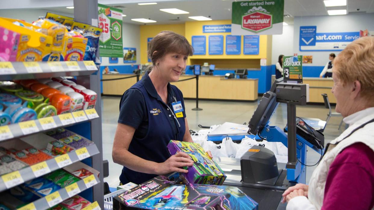 Walmart associate helping checkout customer