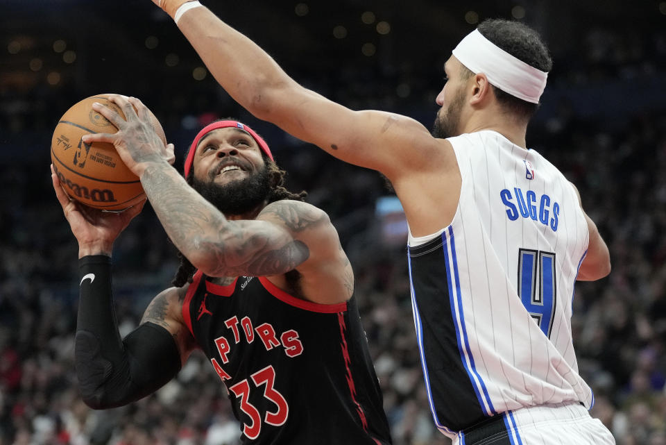 Toronto Raptors guard Gary Trent Jr. (33) isfouled by Orlando Magic guard Jalen Suggs (4) during the first half of an NBA basketball game Friday, March 15, 2024, in Toronto. (Frank Gunn/The Canadian Press via AP)