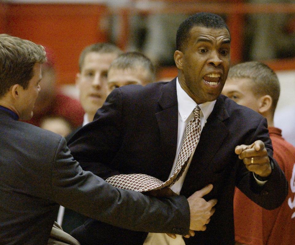 Indiana coach Mike Davis is held back by Dusty May as he argues a call during the second half against Northwestern in Bloomington, Ind., Saturday, Jan. 17, 2004. Indiana won 73-62. (AP Photo/Darron Cummings)