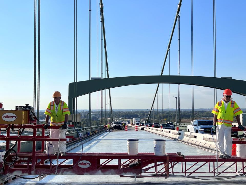 Constructions workers stand on a raised platform on newly poured concrete on two of the four northbound lanes into South Jersey from Delaware on the Delaware River Memorial Bridge.
Traffic delays are possible, especially during rush hours