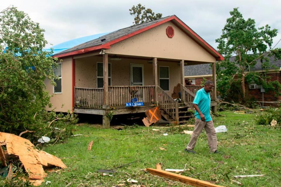 A man walks through the yard of a damaged home in Moss Point on Tuesday, June 20, 2023, after a tornado tore through the town on Monday.