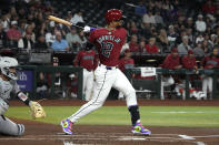 Arizona Diamondbacks' Lourdes Gurriel Jr. follows through on an RBI single against the Colorado Rockies during the first inning of a baseball game, Sunday, March 31, 2024, in Phoenix. (AP Photo/Rick Scuteri)