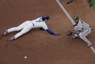 Kansas City Royals' Bobby Witt Jr. (7) beats the tag by Minnesota Twins first baseman Luis Arraez as he dives back to first on a pickoff attempt during the first inning of a baseball game Saturday, May 21, 2022, in Kansas City, Mo. (AP Photo/Charlie Riedel)